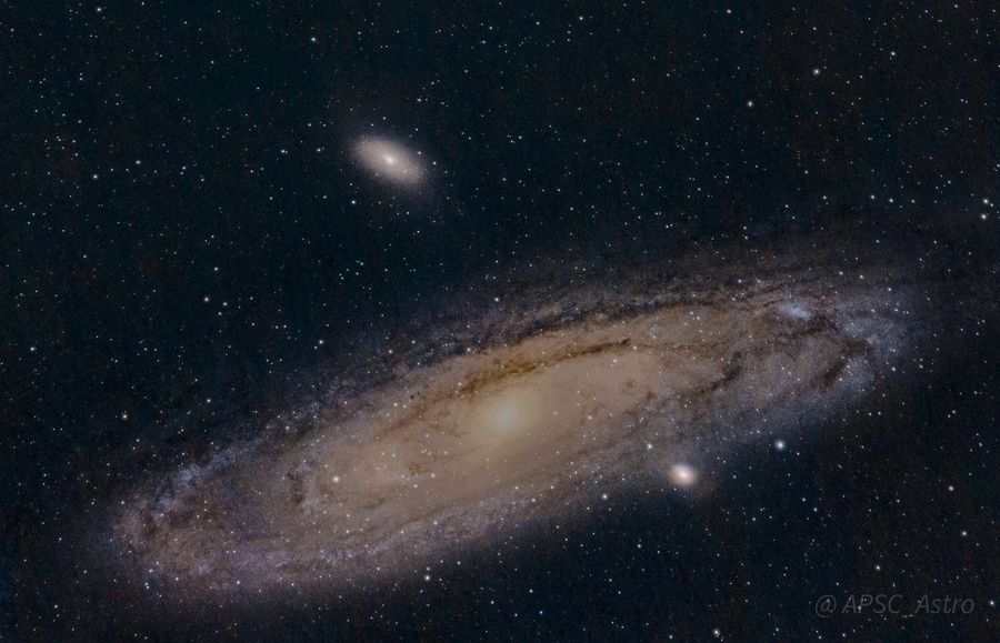 The Andromeda Galaxy with its dust lanes and two satellite galaxies